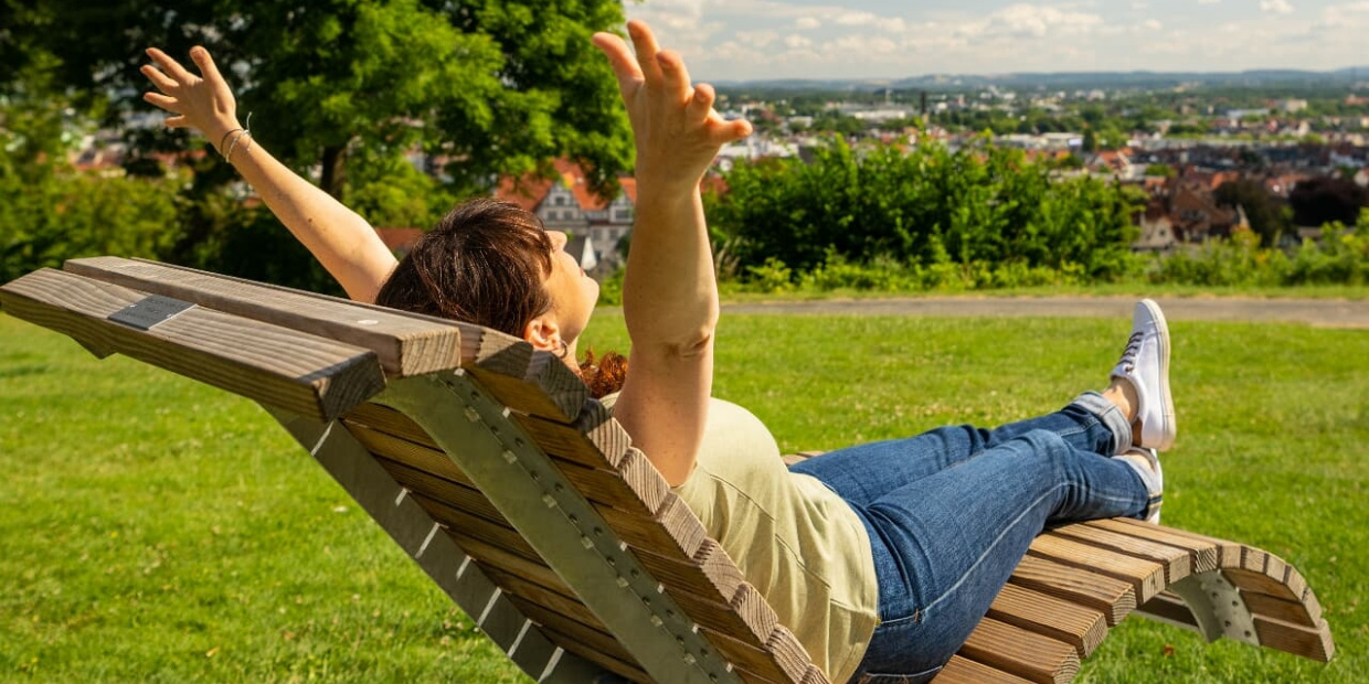 (c) Teutoburger Wald Tourimus | D. Ketz Frau auf Bank mit Blick über Bielefeld