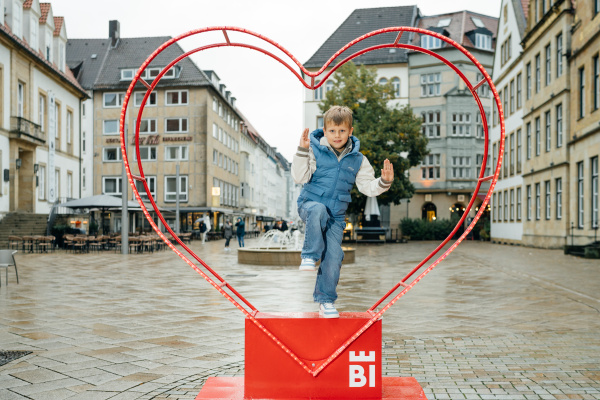 Junge hüpft durch ein Metallherz