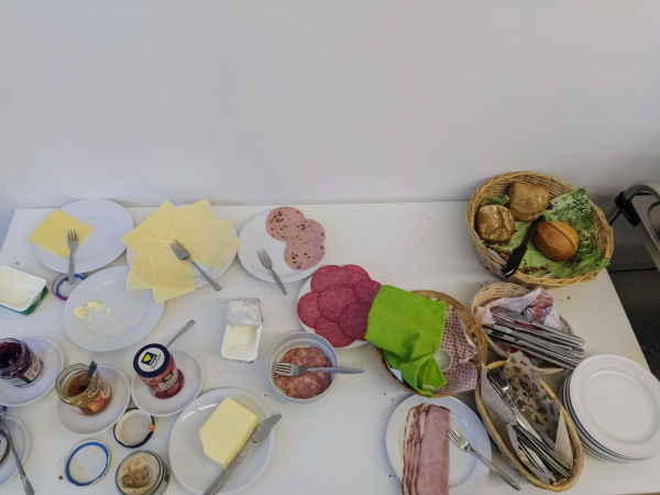 ein Frühstücksbuffet mit Käse, Marmelade, Butter, Wurst, Brötchen
