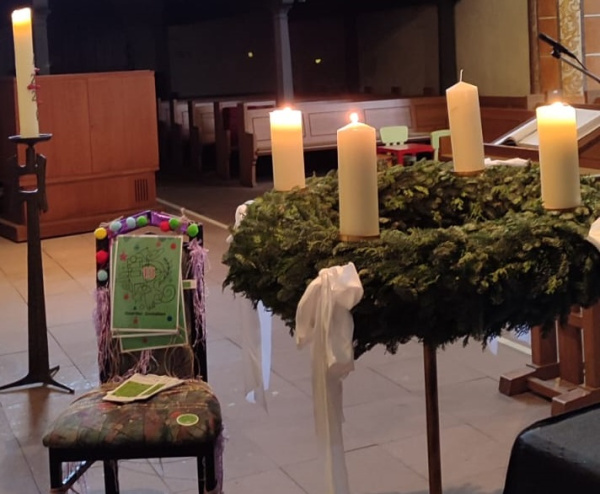 ein Stuhl mit einer Nummer neben einem Adventskranz stehend