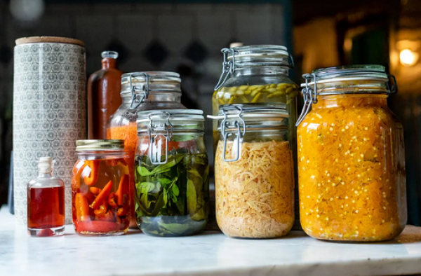 Verschieden hohe Einmachgläser mit fermentiertem Gemüse.