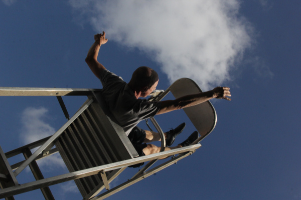 eine Person auf einer Leiter, in den Himmel blickend, als ob die Person schweben würde