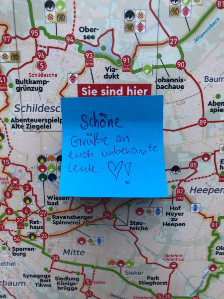 ein Klebezettel mit einem Gruß auf einem Stadtplan