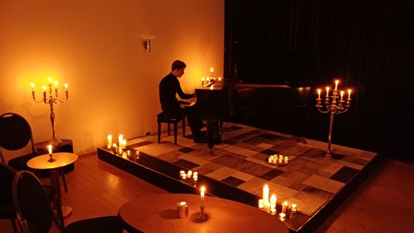 Klavierspieler am Flügel bei Kerzenschein im Studio Nordpark