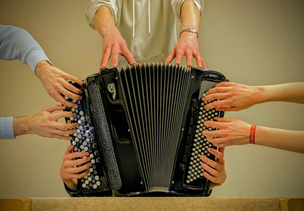 Akkordeon welches von vier Spieler*innen gespielt wird. 