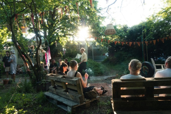Menschen chillen im Garten des Kulturhaus Ostblock. 